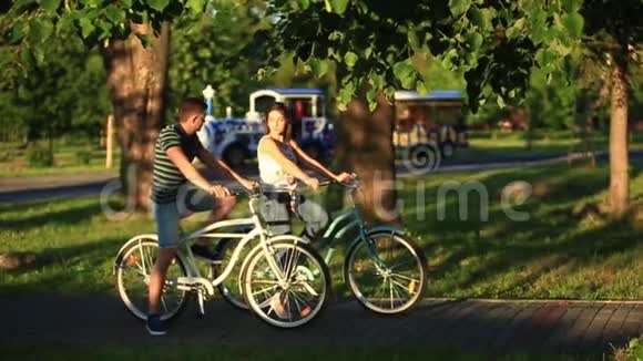 快乐的年轻夫妇喜欢骑自行车阳光明媚的夏天视频的预览图