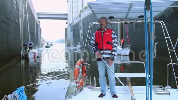 男子驾驶帆船在狭窄的航道游艇视频的预览图