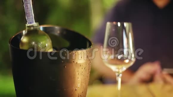 闪闪发光的玻璃杯和一瓶葡萄酒在桶里等待爱情夫妇在餐厅1920x1080视频的预览图