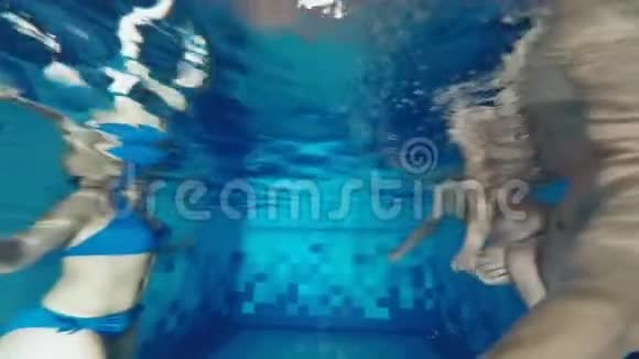 一家人正在游泳池里游泳教一个小儿子在水下游泳的成功尝试视频的预览图