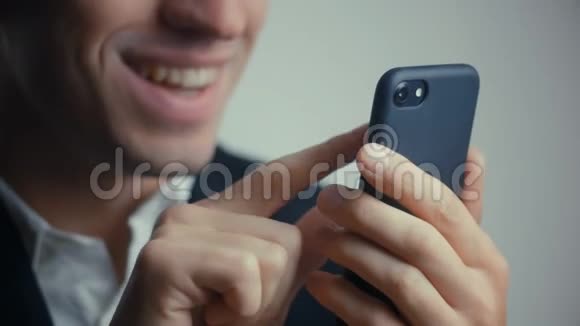 穿西装的微笑快乐商人的特写镜头是用智能手机孤立于白色背景视频的预览图