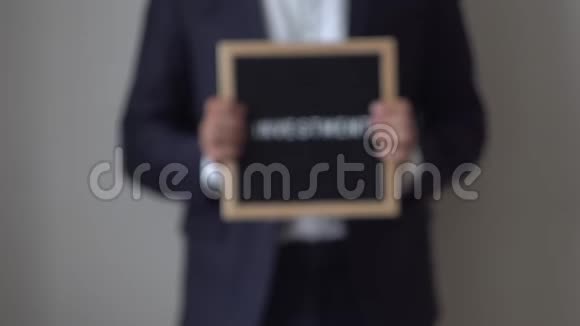 匿名商人手中的文字板上的文字投资视频的预览图