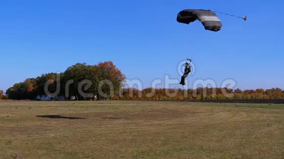 跳伞员带着降落伞飞落在地上慢动作视频的预览图