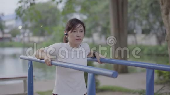 女人在公园的健身机上玩视频的预览图