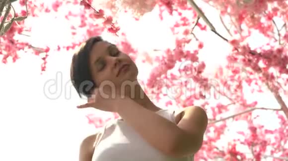 樱花背景上美丽的女孩视频的预览图