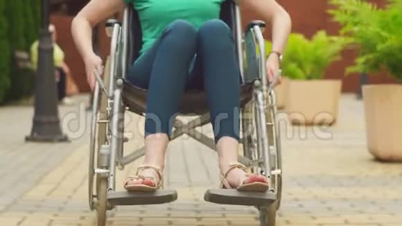 一个坐在轮椅上看着摄像机的残疾女孩的肖像视频的预览图