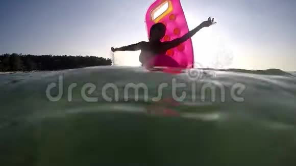 年轻快乐的美丽女子在海上喷水的充气床垫上放松在假期里玩得很开心慢动作视频的预览图