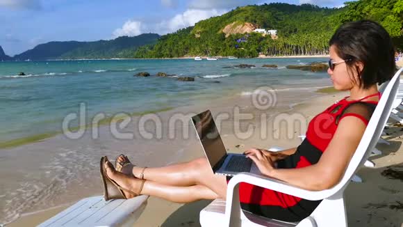 美丽的亚洲女性自由职业者在热带海滩工作视频的预览图