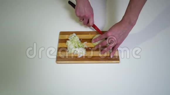 厨房特写镜头一个年轻的女人正在准备食物手的少女特写一个女人用刀切洋葱视频的预览图