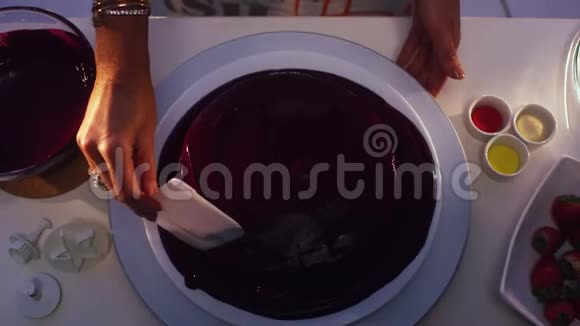 用紫色奶油覆盖的圆形蛋糕正在手工平滑视频的预览图