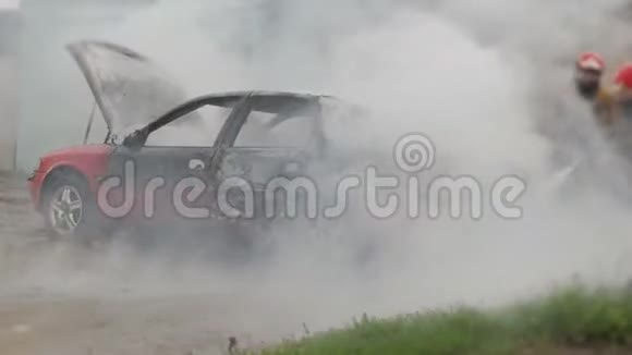 消防队员或消防队员在汽车着火后用软管扑灭燃烧的汽车视频的预览图