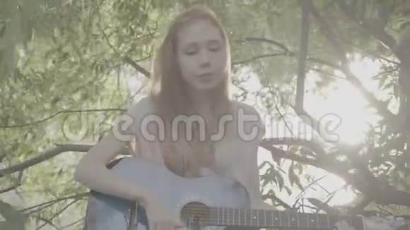 红发女孩在公园里弹吉他彩色侧写博客视频的预览图