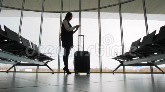 女士在机场使用手机剪影语音留言帮助助手识别行李视频的预览图