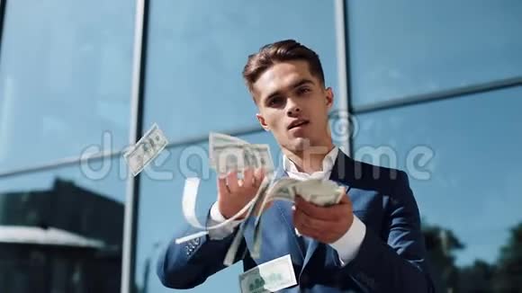 快乐成功的商人把钱扔给相机金钱雨美元跌慢动作成功的业务视频的预览图