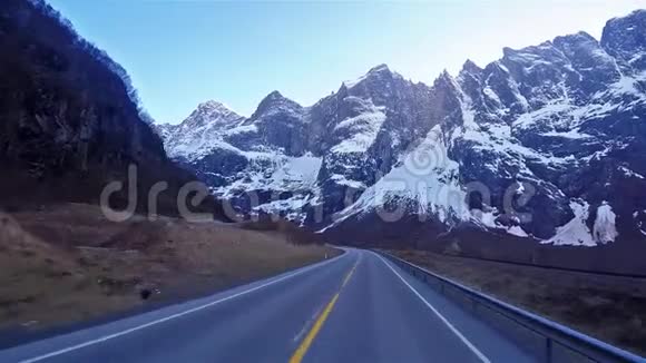 挪威行驶道路的正面景观穿过大雪覆盖的高山视频的预览图