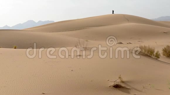 一个孤独的女孩沿着沙丘散步视频的预览图