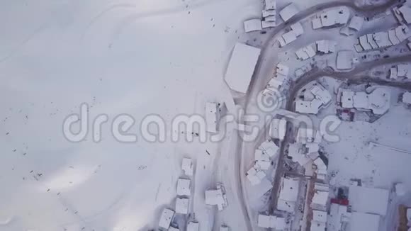 滑雪胜地从天空观看旋转显示房屋和黑点滑雪者视频的预览图