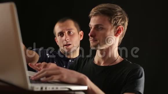 两个微笑的创业商人在讨论共享笔记本电脑的问题视频的预览图