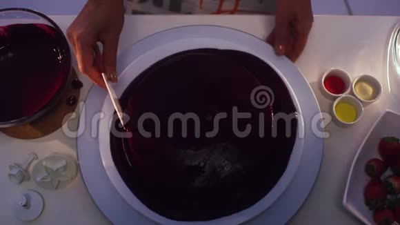 用紫霜覆盖的圆形蛋糕旋转并用卡片抚平视频的预览图