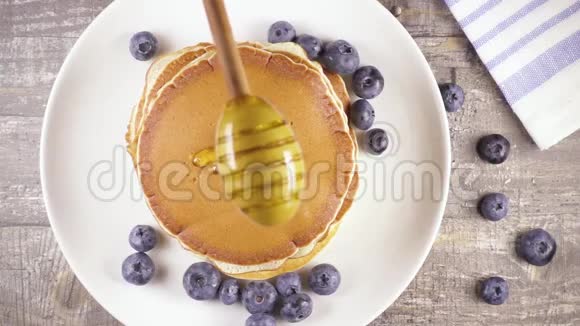 早餐提供带浆果和蜂蜜的慢动作煎饼视频的预览图