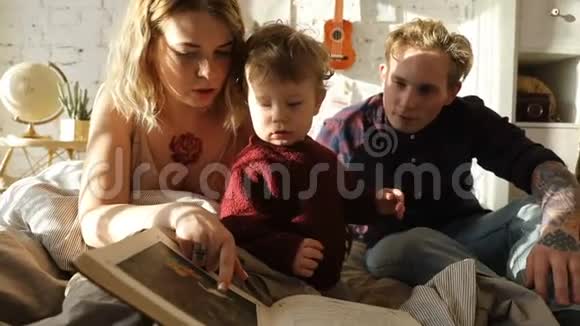 年轻的父母带着男孩看书视频的预览图