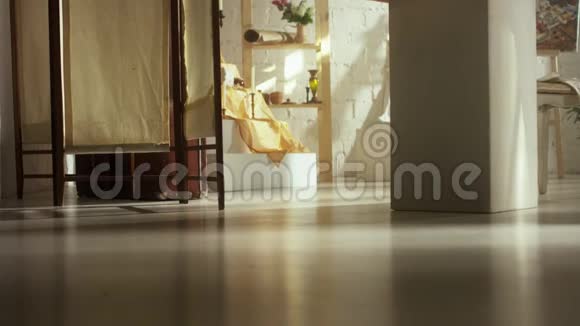 女人光着脚在光天化日之下明亮的装修房间的无盖地板上行走视频的预览图
