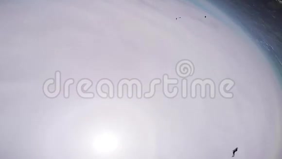 专业跳伞者在空中打开降落伞在绿色的平地上飞翔云层视频的预览图