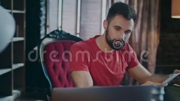 专注的人在家里工作的地方工作笔记本电脑家庭事务视频的预览图