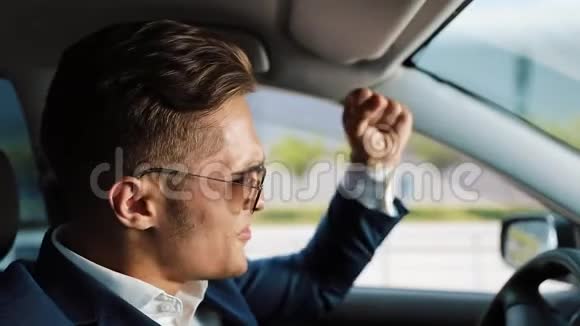 沮丧和非常沮丧的年轻商人在车里一个男人在生意上的车轮问题上喝酒或者视频的预览图