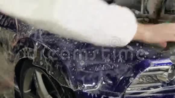 近距离拍摄的人手施加清晰的肥皂膜在车辆的保险杠视频的预览图
