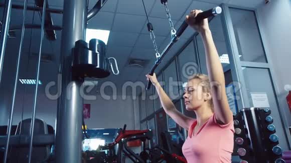 一个在健身房训练模拟器的迷人女孩视频的预览图