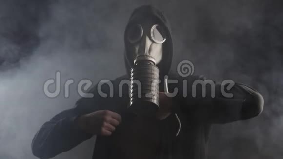 戴防毒面具的人在烟雾弥漫的黑暗房间里脱衣服视频的预览图