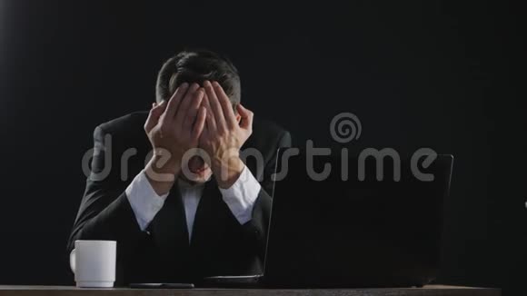 悲伤的商人坐在办公室的办公桌前哭泣视频的预览图