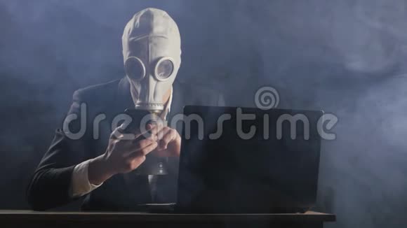 戴着防毒面具的商人在黑暗的办公室工作视频的预览图