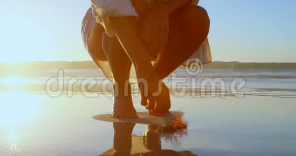 在海滩上拿着干植物的女人视频的预览图
