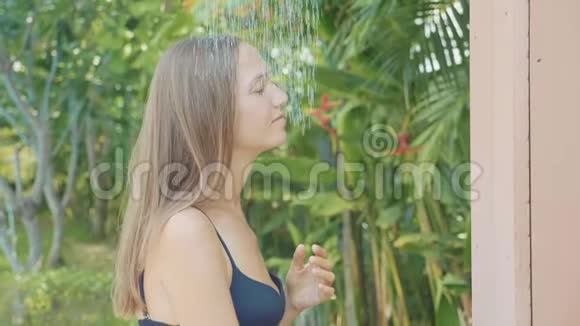 勇美女在游泳池室外慢动作淋浴视频的预览图