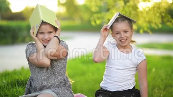 两个有趣的女孩在玩书他们在微笑玩得很开心天气晴朗视频的预览图