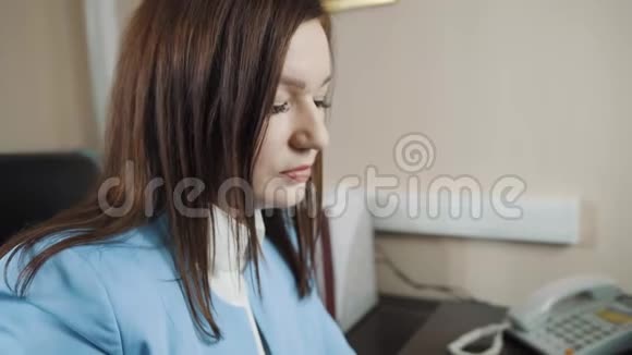 办公室里穿着蓝色夹克的黑发女商人喝咖啡视频的预览图