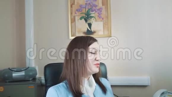 快乐的黑发女商人从椅子上站起来离开办公室视频的预览图
