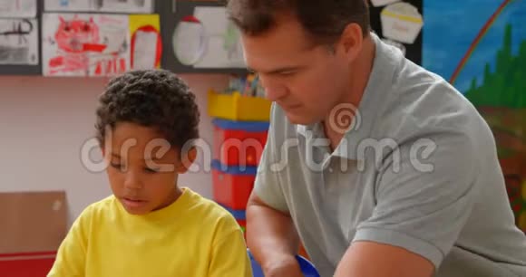 白人年轻男教师在4k教室教非裔美国小学生的正面看法视频的预览图
