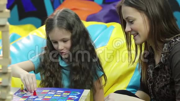 微笑女孩玩棋盘游戏姐姐家庭交往教育视频的预览图