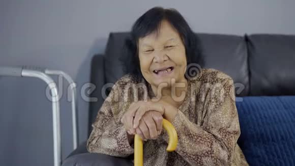 老妇人在客厅里笑着拿着木杖视频的预览图