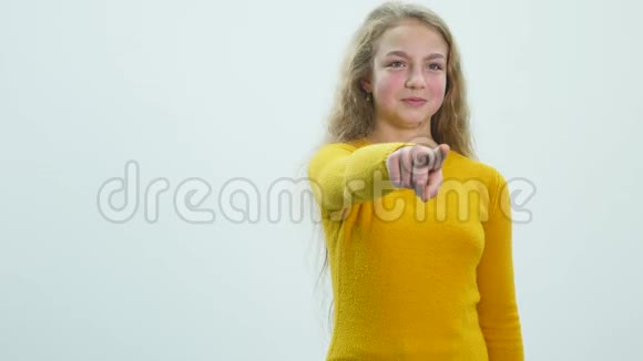 小女孩在白色背景前用手指对着镜头视频的预览图