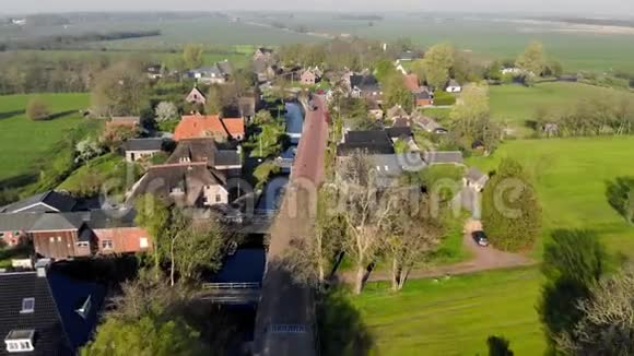 鸟瞰荷兰小美丽乡村飞过一个小村庄的房屋和街道的屋顶视频的预览图