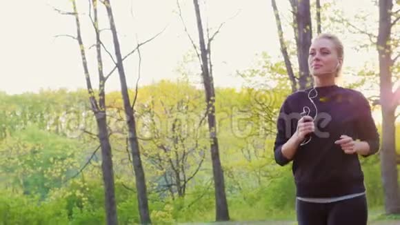 慢镜头一位迷人的年轻女子在森林里晨跑1阳光明媚视频的预览图