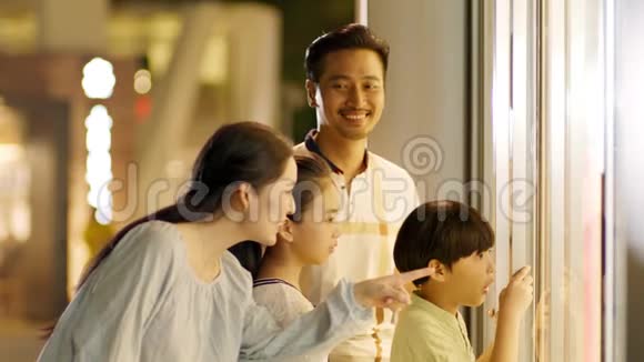 亚洲家庭4人站立缓慢地看着橱窗视频的预览图