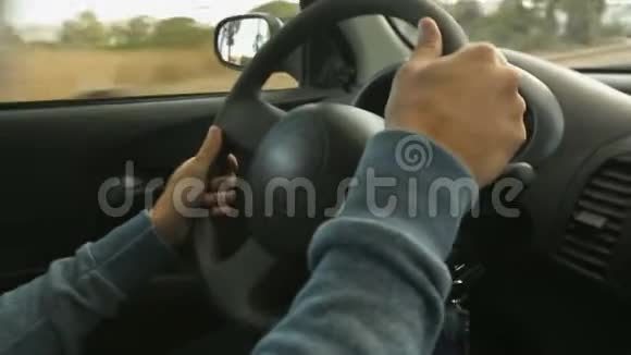男子汉的双手紧紧地握着汽车在城市中的方向盘视频的预览图