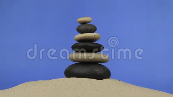 走近躺在沙子上的石头做成的金字塔孤立视频的预览图