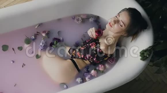 有魅力的女孩沐浴着牛奶和花蕾水疗治疗皮肤年轻化年轻漂亮的女人视频的预览图