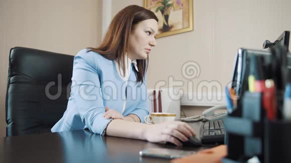 女商人黑发女人坐在办公室在电脑上工作视频的预览图